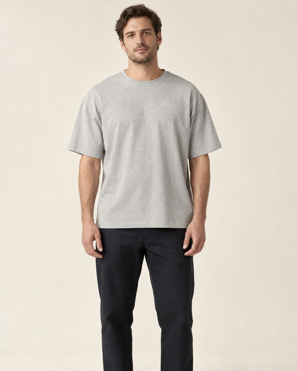 Man wearing a loose grey T-shirt for fit comparison